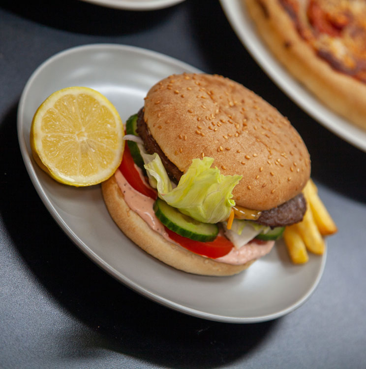 Mama Mia Hamburger with lettuce, tomato, cucumber and pink sauce.